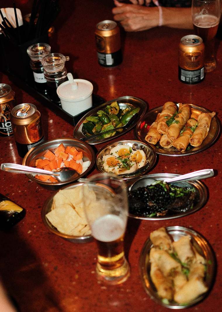 A table of spring rolls, soy eggs and sides