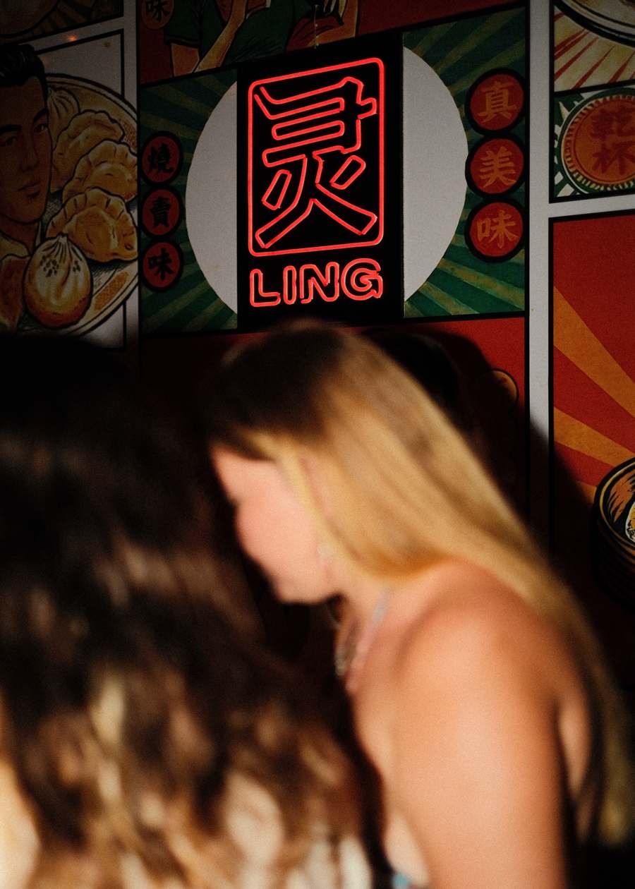 The neon 灵 LING sign on the poster wall
